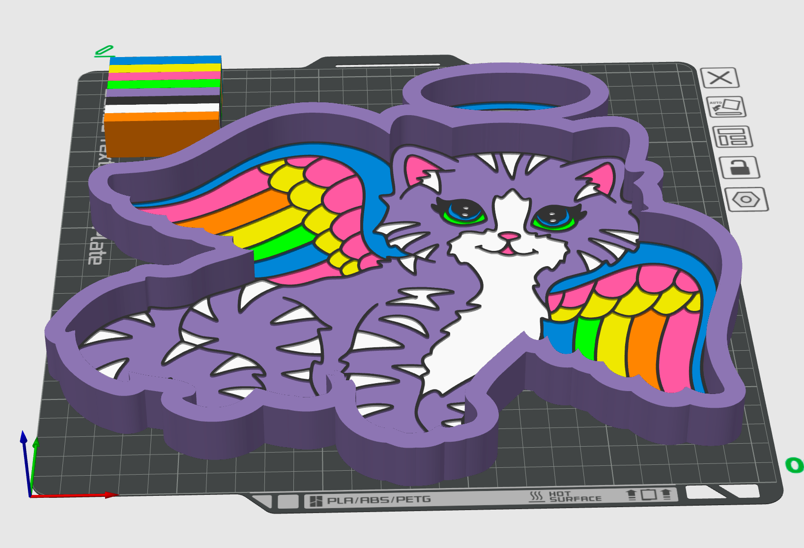 A 3D digital render of a purple cat-shaped cookie cutter or mold, featuring a white cat face, colorful rainbow wings, and sharp claw-like edges, shown on a gray gridded design software workspace background.