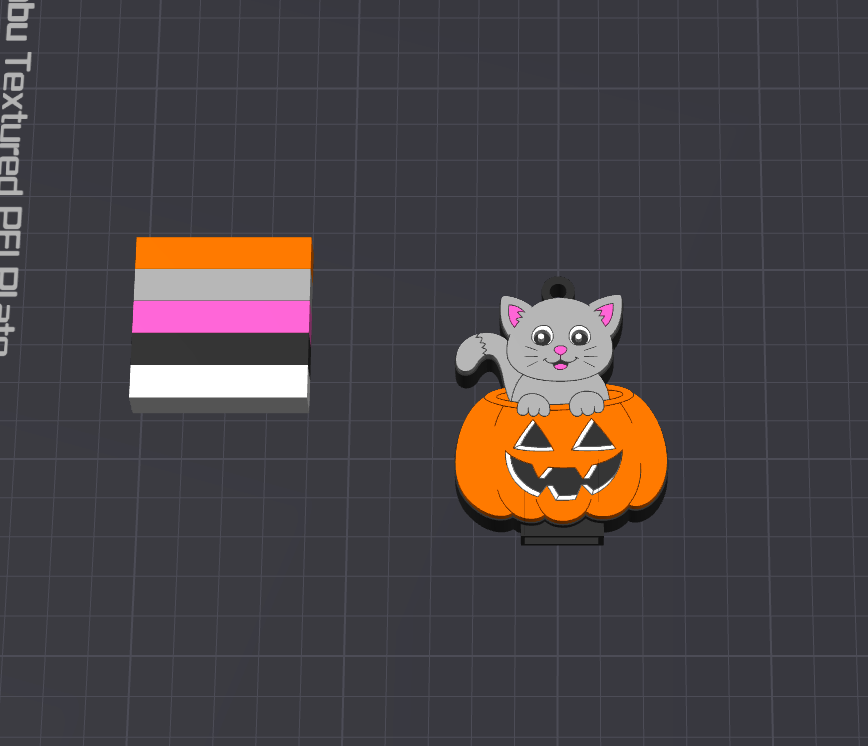 A small cartoon pin or charm showing a gray cat sitting on an orange jack-o'-lantern, displayed on a dark grid background next to a vertical color swatch strip with orange, gray, pink, black, and white sections.