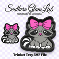 Digital product preview for a Southern Glam Lab handmade in Louisiana trinket tray 3MF file, featuring a cartoon raccoon with a pink bow in two sizes on a checkered background.